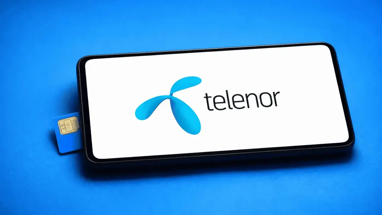 En blå Telenor simkort ligger bredvid en smartphone med Telenors logotyp på skärmen.