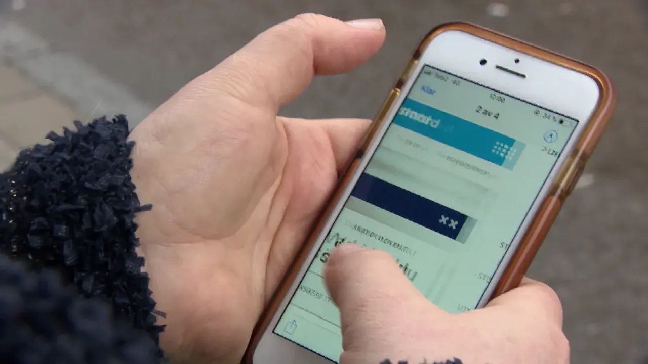 En hand håller en mobiltelefon där en person verkar ha råkat teckna en bluff-sms prenumeration.