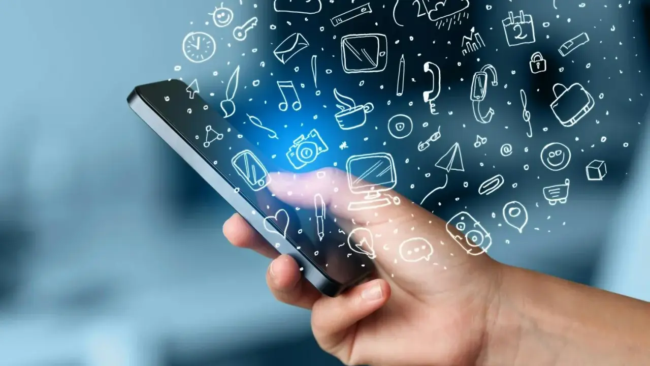 En hand håller en mobil med en mängd ikoner som svävar ut, som ett digitalt måttband i mobilen som mäter allt från väder till kommunikation.
