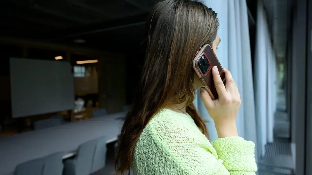Kvinna pratar i telefon, kanske ett bluffsamtal med svenskt nummer.
