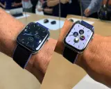 Två Apple Watch med snygga urtavlor som visar tid, datum och hälsodata. En med mörk urtavla, den andra med ljus.