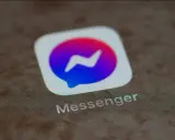 Messenger-ikonen med dess blåa och lila färggradient. Kanske en symbol för en blockad på Messenger, där kommunikationen avbryts.