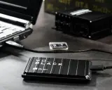 En bärbar dator är ansluten till ett WD_BLACK externt lagringsutrymme. Förbered dig på att formatera ditt USB-minne för snabb dataöverföring.