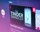 Netflix-skärmen visar "The Tinder Swindler", en dokumentär om tinder bilder på bedragare. En fiskekrok med en diamantring hänger i en mobil.
