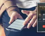 Person håller en mobiltelefon med en aktiv telefonsamtalsskärm. Skärmen visar nummer och alternativ för att hantera samtalet, som hur ringer man dolt.
