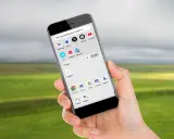 En hand håller en telefon med en öppen app-meny. Det är dags att uppdatera telefonen för att få tillgång till alla appar.