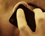 En person lyssnar på sin mobiltelefon. Vem ringde från utlandet 44?