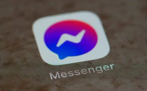 Messenger-ikonen med dess blåa och lila färggradient. Kanske en symbol för en blockad på Messenger, där kommunikationen avbryts.