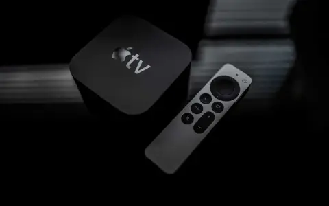 Apple TV och fjärrkontroll på mörk bakgrund. Dags att starta om Apple TV för en fräsch start.