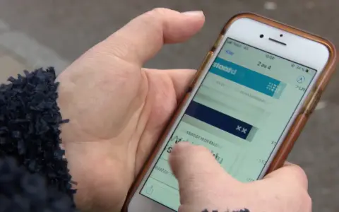 En hand håller en mobiltelefon där en person verkar ha råkat teckna en bluff-sms prenumeration.