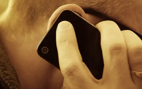 En person lyssnar på sin mobiltelefon. Vem ringde från utlandet 44?