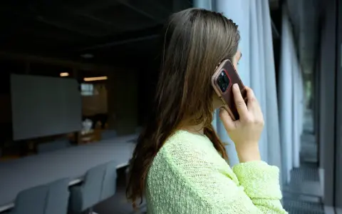 Kvinna pratar i telefon, kanske ett bluffsamtal med svenskt nummer.