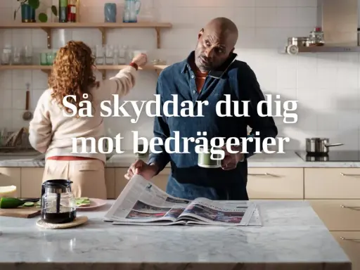 Man i köket pratar i telefon och läser tidningen, medan en kvinna plockar på hyllan. Texten "Så skyddar du dig mot bedrägerier" antyder att "vad betyder cyber" är en viktig fråga för att undvika bedrägerier.