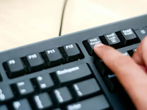 En finger trycker på "Print Screen"-knappen på ett tangentbord. Så här tar man screenshot på datorn.