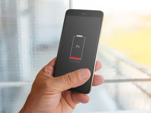 En hand håller en mobil med lågt batteri, 3%. Dags att kolla vilka appar som drar mest batteri.
