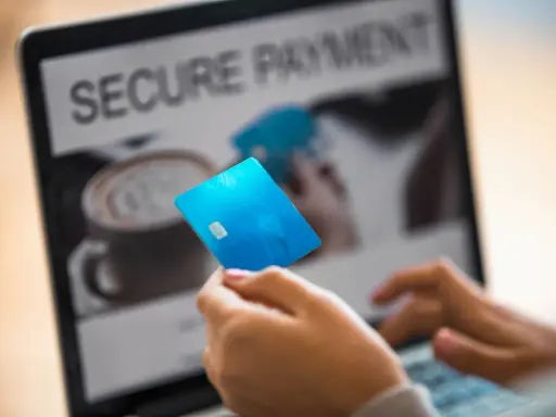 Person håller blått kreditkort framför laptop med texten "SECURE PAYMENT". Tänk om någon har kivra hackat.