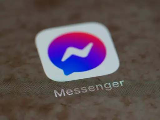 Messenger-ikonen med dess blåa och lila färggradient. Kanske en symbol för en blockad på Messenger, där kommunikationen avbryts.