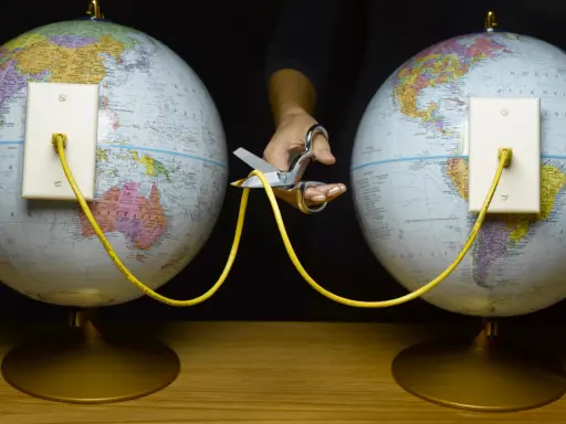 En hand med sax klipper av en gul kabel som kopplar ihop två jordglober. Vem skapade wifi?