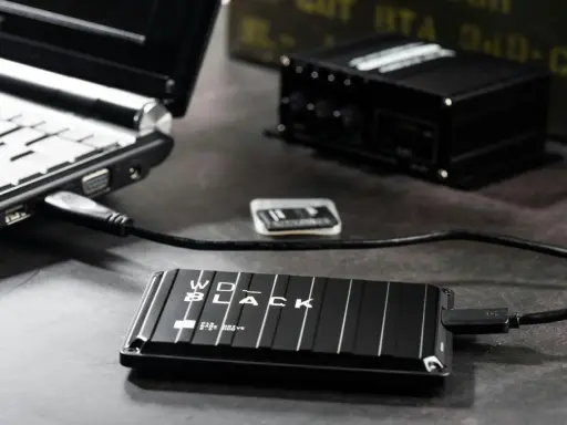 En bärbar dator är ansluten till ett WD_BLACK externt lagringsutrymme. Förbered dig på att formatera ditt USB-minne för snabb dataöverföring.