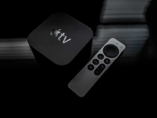 Apple TV och fjärrkontroll på mörk bakgrund. Dags att starta om Apple TV för en fräsch start.