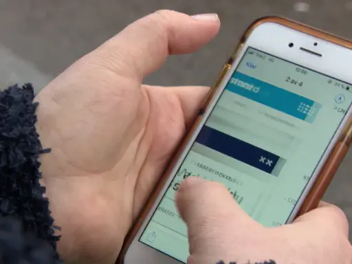 En hand håller en mobiltelefon där en person verkar ha råkat teckna en bluff-sms prenumeration.