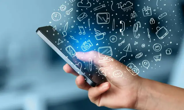 En hand håller en mobil med en mängd ikoner som svävar ut, som ett digitalt måttband i mobilen som mäter allt från väder till kommunikation.