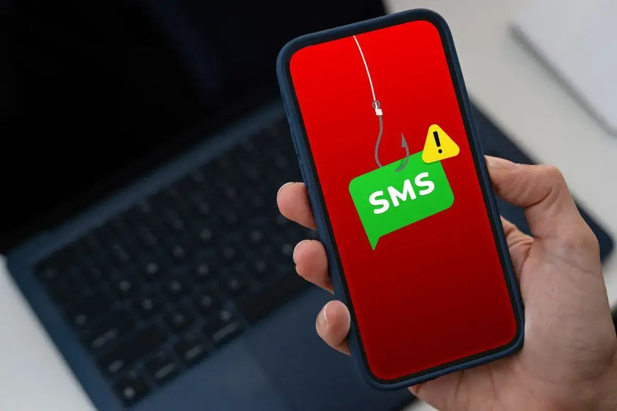 Varning f&ouml;r tele2 bluff-sms! En fiskekrok h&auml;nger &ouml;ver en SMS-bubbla p&aring; en mobilsk&auml;rm, en varning f&ouml;r bedr&auml;geri.