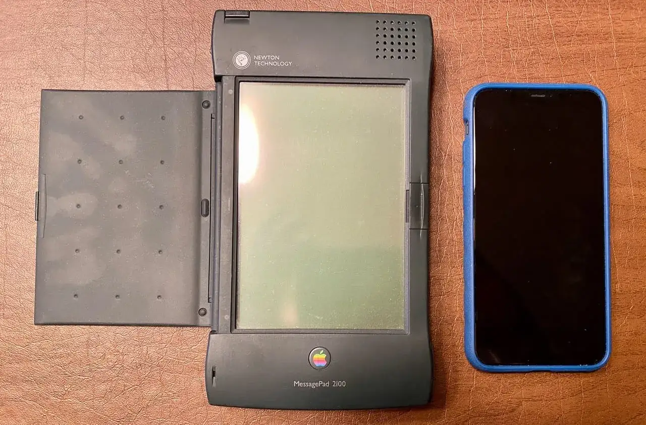 En Apple Newton MessagePad 2100 bredvid en modern smartphone.