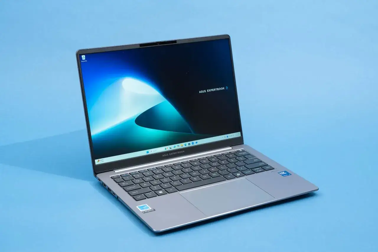 En &ouml;ppen gr&aring; ASUS ExpertBook-dator med en bl&aring; bakgrund. Perfekt f&ouml;r dig som vill byta dator och uppgradera din teknik.