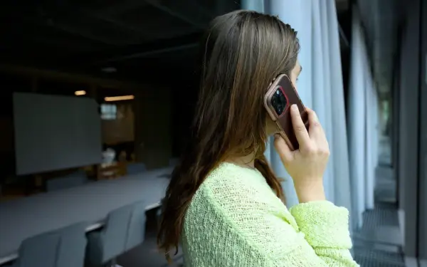 Kvinna pratar i telefon, kanske ett bluffsamtal med svenskt nummer.